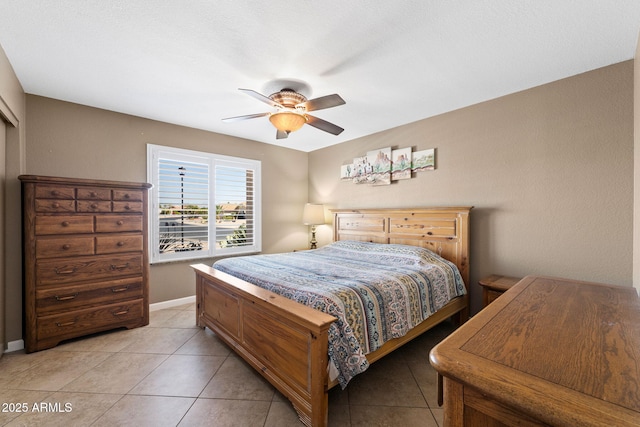 bedroom featuring light tile patterned floors, ceiling fan, and baseboards