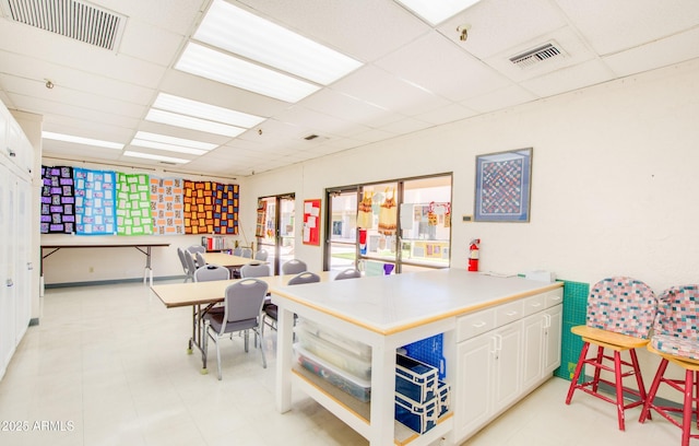 rec room featuring a paneled ceiling and visible vents