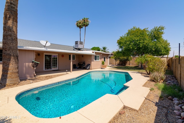 view of swimming pool featuring central AC unit and a patio