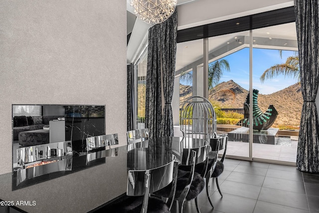 tiled dining room featuring a notable chandelier and a mountain view