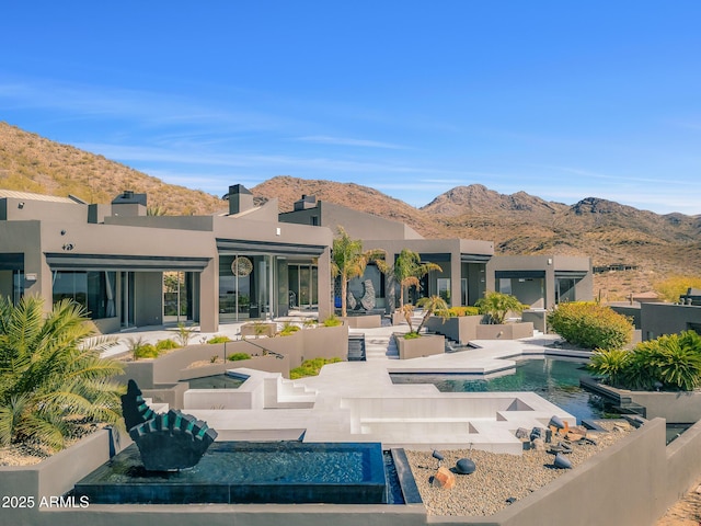 back of house with an outdoor pool, a patio area, a mountain view, and fence