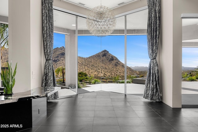 interior space with a chandelier, visible vents, plenty of natural light, and a mountain view