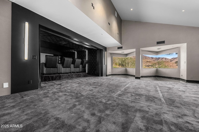 unfurnished living room with carpet floors, high vaulted ceiling, and visible vents