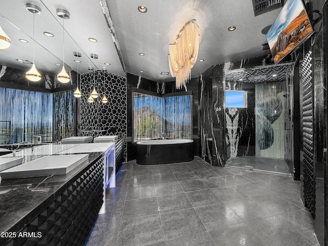 bathroom featuring a freestanding bath, double vanity, a walk in shower, and a wealth of natural light