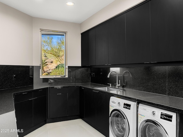 laundry room featuring washing machine and dryer, a sink, cabinet space, and recessed lighting