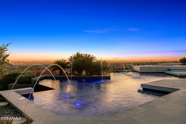 view of pool at dusk