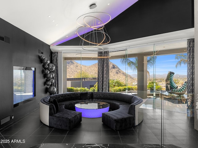 sunken living room with lofted ceiling, visible vents, an inviting chandelier, a mountain view, and tile patterned floors