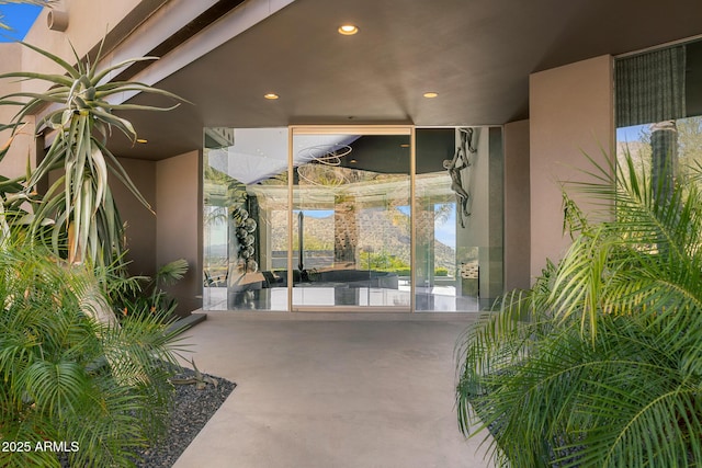 view of exterior entry with a balcony and stucco siding