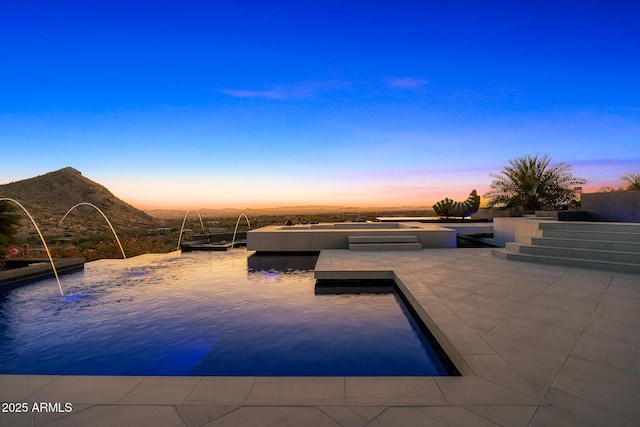 pool at dusk featuring a boat dock and a mountain view