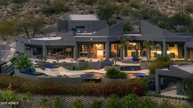 back of property featuring a patio area and stucco siding