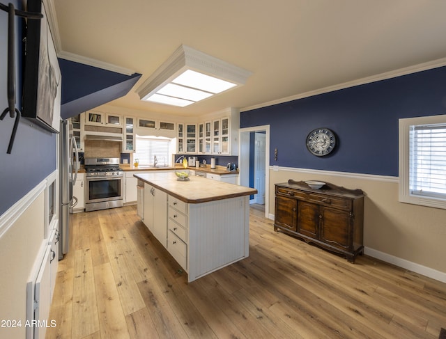 kitchen featuring a kitchen island, white cabinets, stainless steel appliances, and light wood-type flooring