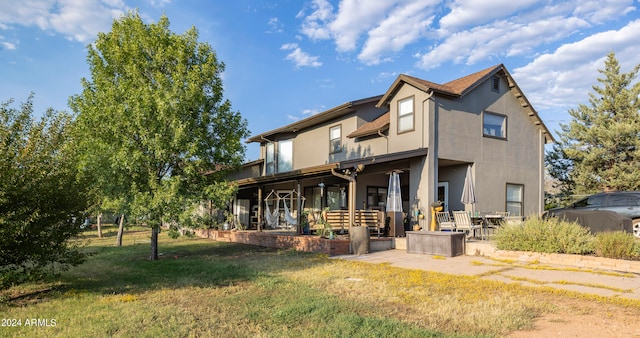 rear view of property featuring a patio, ceiling fan, and a lawn