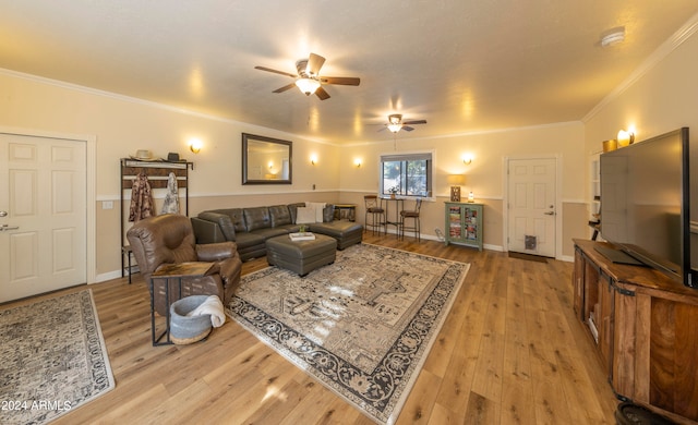 living room featuring hardwood / wood-style floors, crown molding, and ceiling fan