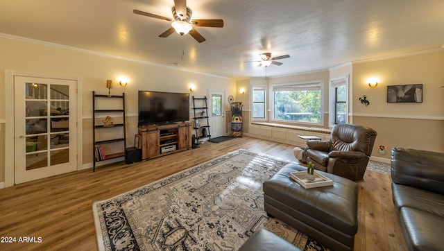 living room featuring ornamental molding, light hardwood / wood-style flooring, and ceiling fan