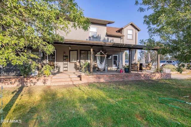 rear view of house with a patio area and a lawn