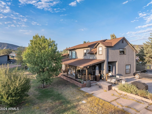 view of front of house with an outdoor hangout area, a mountain view, and a patio area