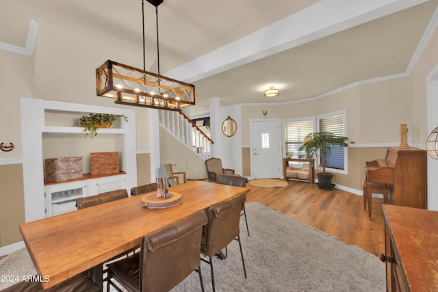 dining space featuring crown molding and light hardwood / wood-style flooring