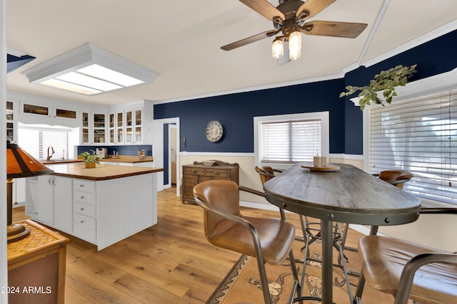 kitchen with butcher block counters, sink, light wood-type flooring, white cabinets, and ceiling fan