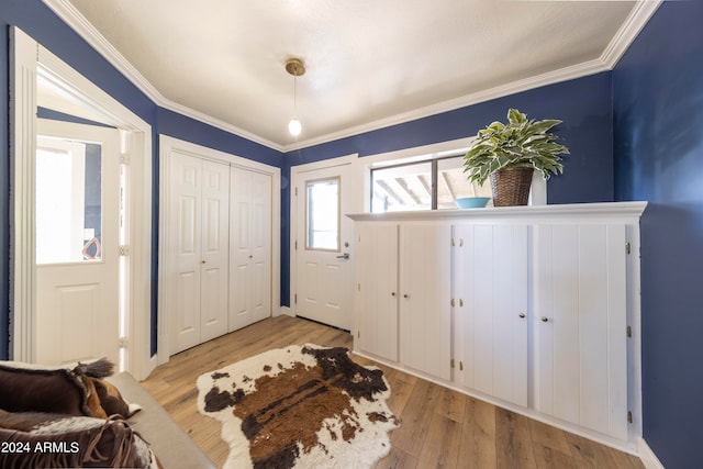 foyer entrance featuring ornamental molding and light hardwood / wood-style flooring