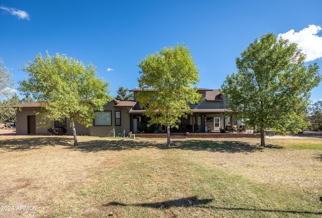 view of property hidden behind natural elements featuring a front lawn