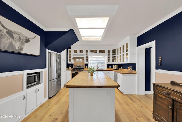 kitchen featuring appliances with stainless steel finishes, white cabinets, a center island, and light hardwood / wood-style floors