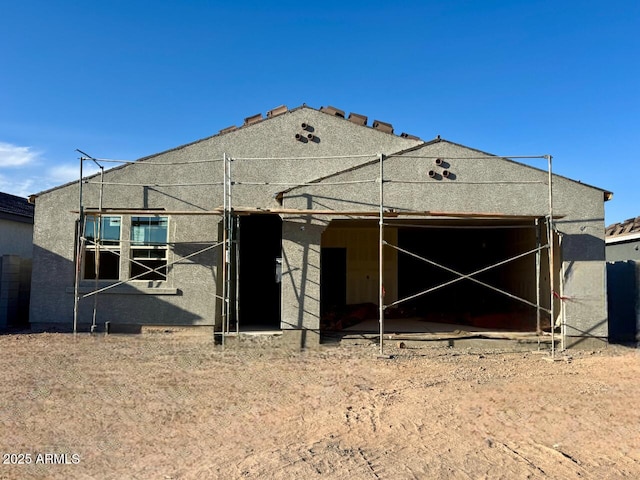 rear view of house featuring stucco siding