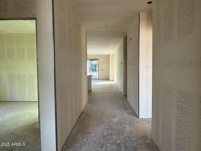 corridor featuring unfinished concrete flooring