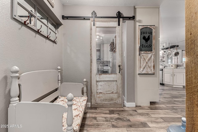 full bath with a freestanding bath, a textured wall, wood finished floors, and vanity