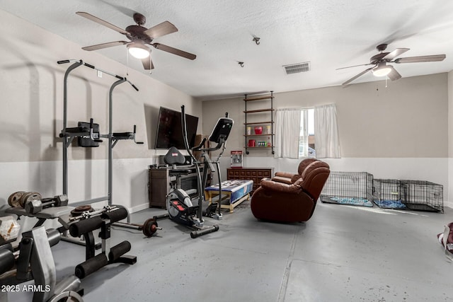 exercise room featuring a textured ceiling, visible vents, and a ceiling fan