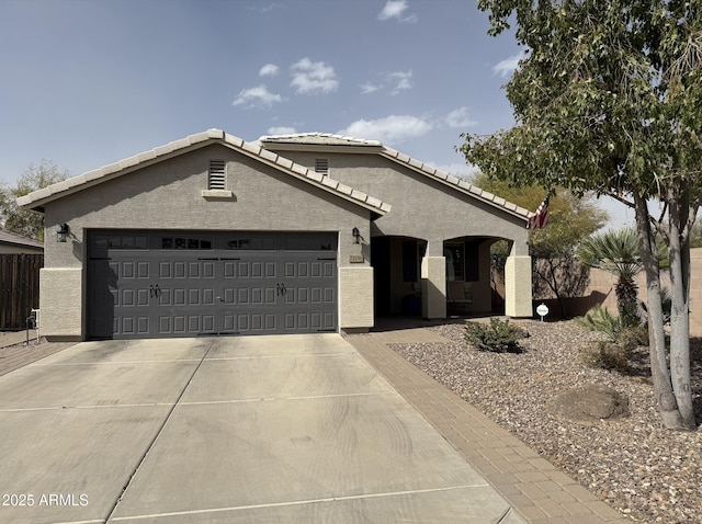 single story home with a garage, driveway, a tiled roof, fence, and stucco siding