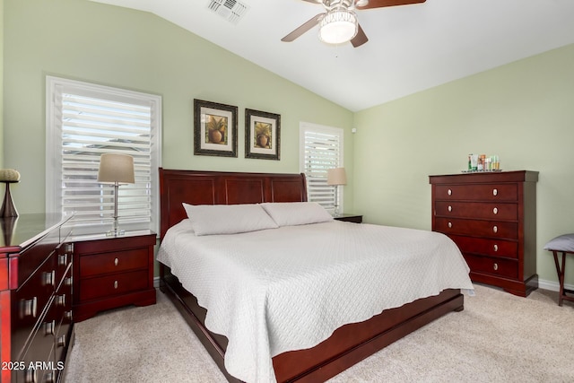 bedroom featuring a ceiling fan, visible vents, vaulted ceiling, and light carpet