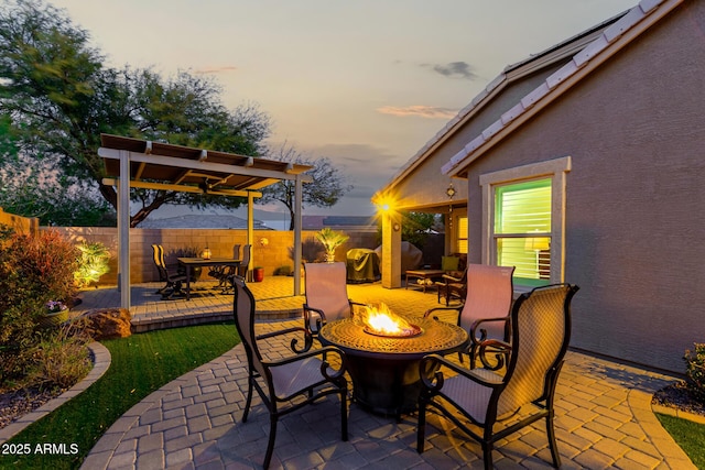 view of patio with a fire pit and fence