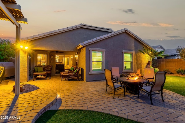 view of patio with a grill, fence, a ceiling fan, and an outdoor living space with a fire pit