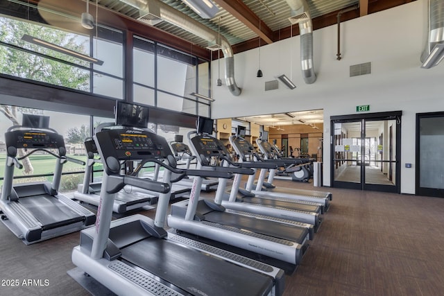 gym with visible vents and a high ceiling