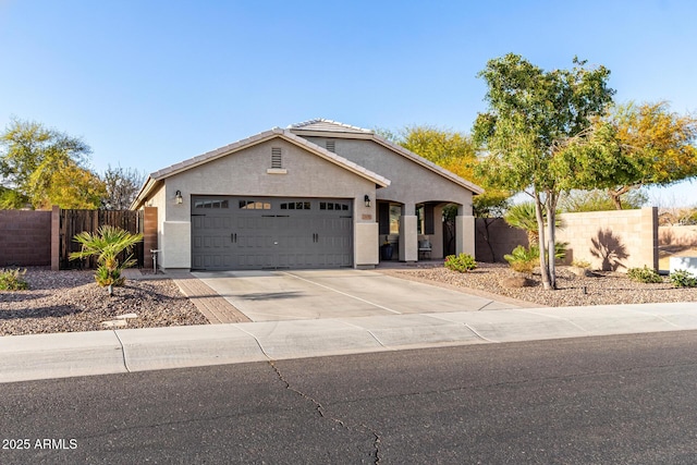 view of front of home with a garage, fence, driveway, and stucco siding