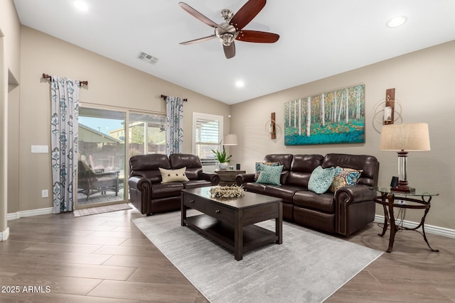 living room featuring visible vents, a ceiling fan, vaulted ceiling, wood finished floors, and baseboards