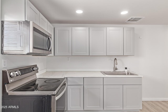 423 W Phoenix Ave, Eloy, AZ 85131 - kitchen featuring a sink, appliances with stainless steel finishes, light wood-type flooring, visible vents, and recessed lighting