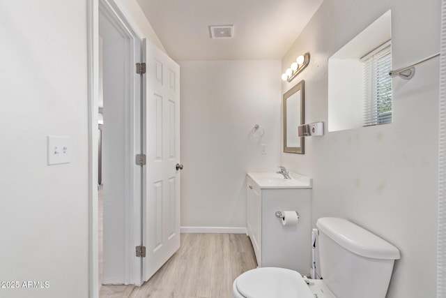 423 W Phoenix Ave, Eloy, AZ 85131 - bathroom with visible vents, baseboards, toilet, wood finished floors, and vanity