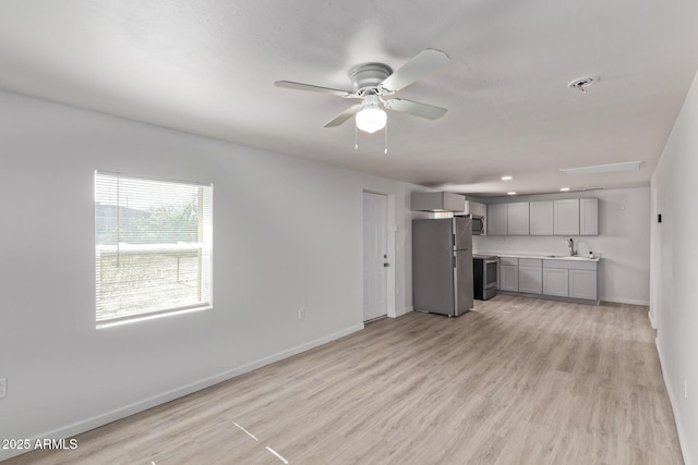423 W Phoenix Ave, Eloy, AZ 85131 - unfurnished living room featuring baseboards, a sink, a ceiling fan, and light wood finished floors