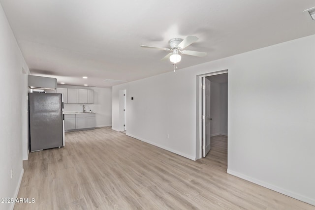 423 W Phoenix Ave, Eloy, AZ 85131 - unfurnished living room featuring baseboards, light wood-style floors, a sink, and a ceiling fan