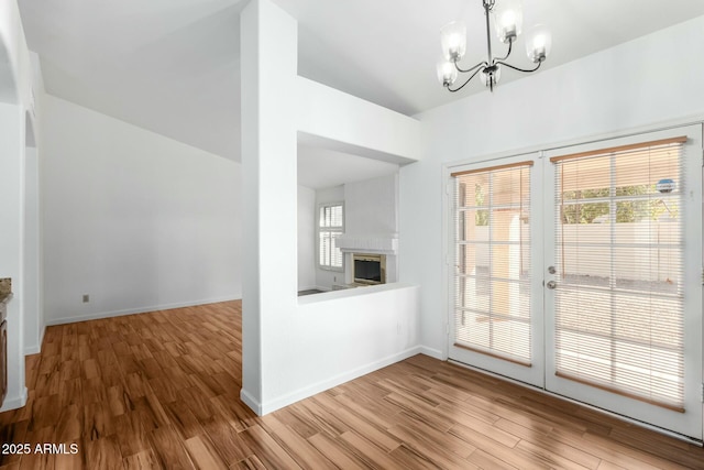 interior space with an inviting chandelier, plenty of natural light, and light hardwood / wood-style floors