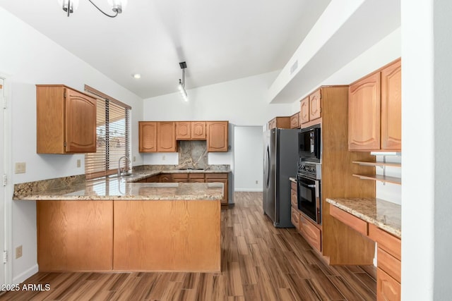 kitchen with light stone counters, black appliances, dark hardwood / wood-style floors, kitchen peninsula, and backsplash