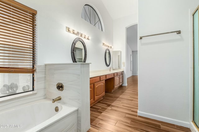 bathroom with a washtub, vanity, and hardwood / wood-style flooring