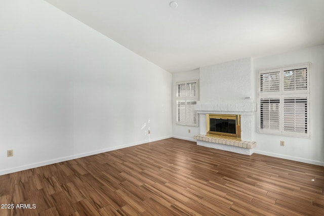 unfurnished living room with a brick fireplace and hardwood / wood-style flooring