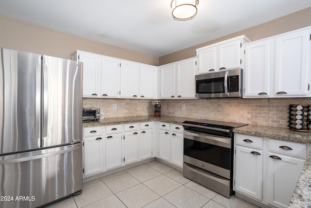 kitchen with decorative backsplash, white cabinets, and stainless steel appliances