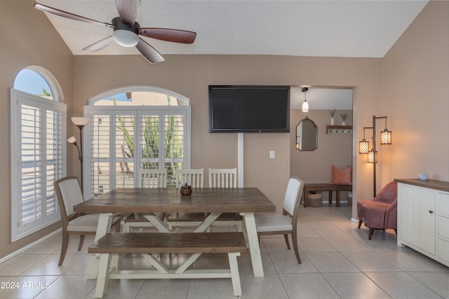 dining space with lofted ceiling, ceiling fan, a textured ceiling, and light tile patterned floors