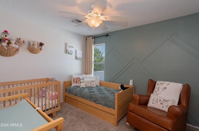 bedroom featuring ceiling fan, a textured ceiling, and carpet floors