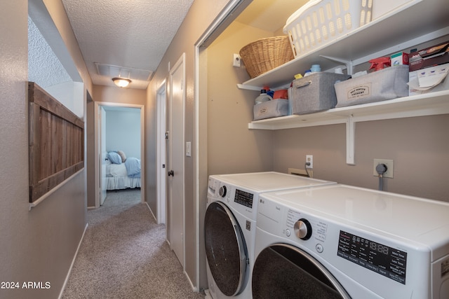 laundry room with washer and dryer, light carpet, and a textured ceiling