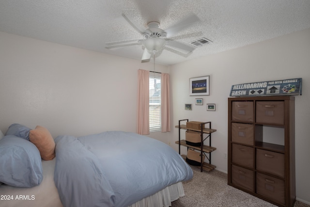 carpeted bedroom featuring a textured ceiling and ceiling fan