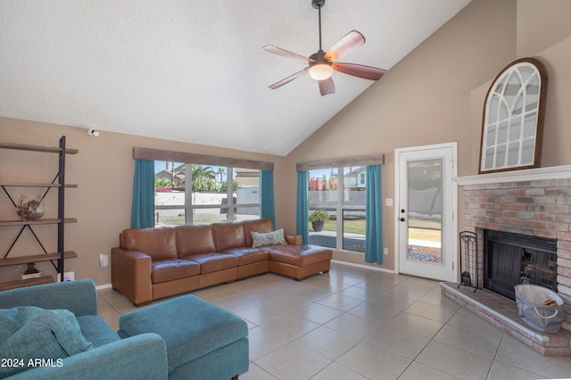 living room with a brick fireplace, ceiling fan, high vaulted ceiling, and a wealth of natural light